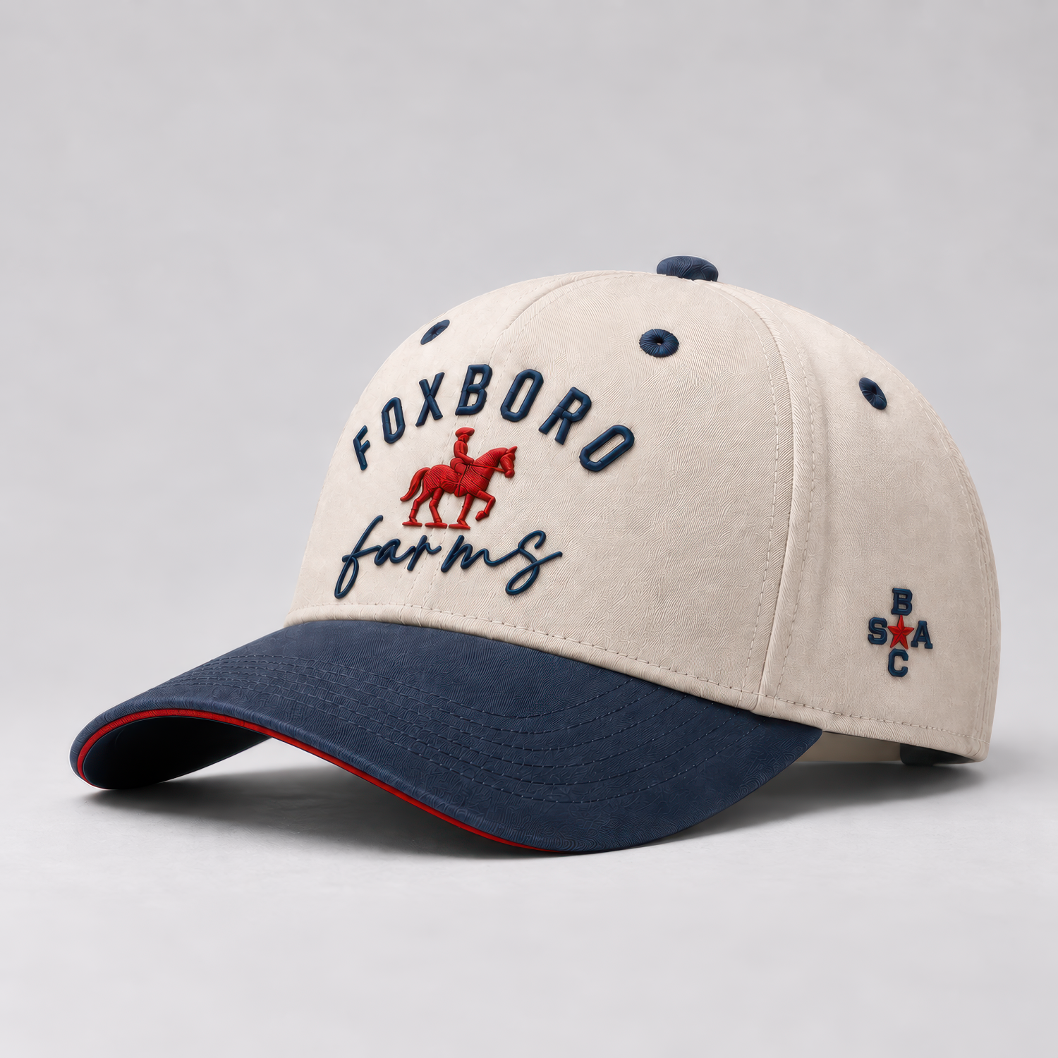 Foxboro Farms hat with a cream crown, navy brim and lettering, and red horse-and-rider detail